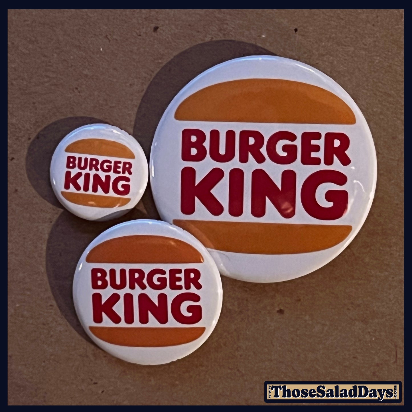 Three Burger King buttons on a brown background