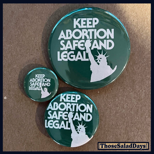 Three green buttons with 'Keep Abortion Safe and Legal' text and a silhouette of the Statue of Liberty on a brown background.