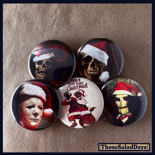 Set of five buttons with Halloween and christmas themed designs featuring skulls and masks with Santa hats
