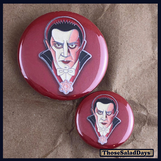 Two buttons of a colorful monster. One size is 1" and the other is 1.5".