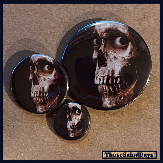 Three buttons of an Evil Dead type image. One size is 1", 1.5" and 2.25".