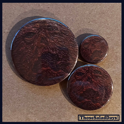 Three buttons of an Evil Dead type image. One size is 1", 1.5" and 2.25".