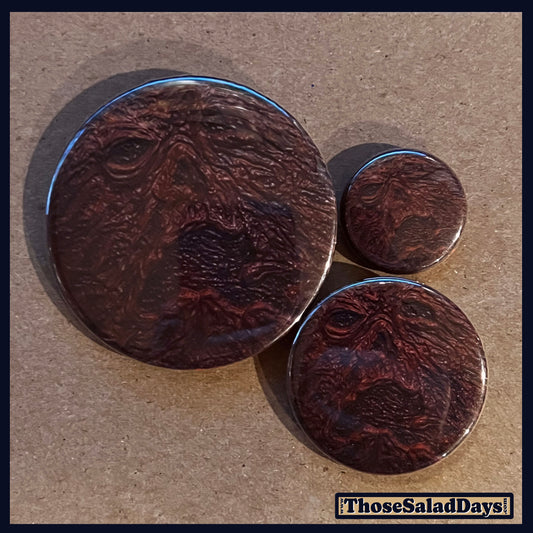Three buttons of an Evil Dead type image. One size is 1", 1.5" and 2.25".