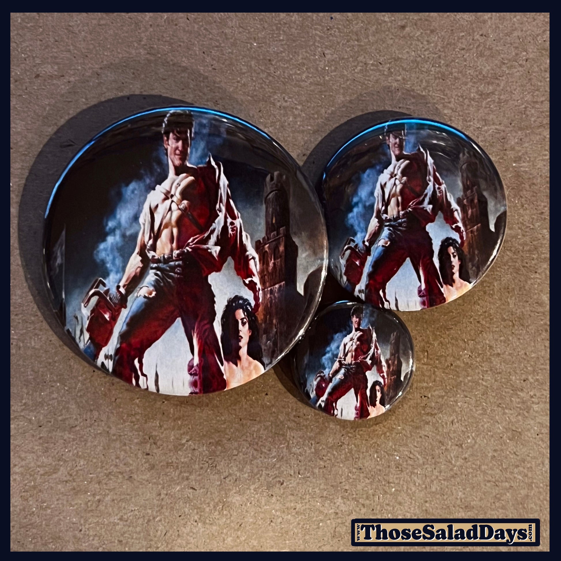 Three buttons of an Evil Dead type image. One size is 1", 1.5" and 2.25".