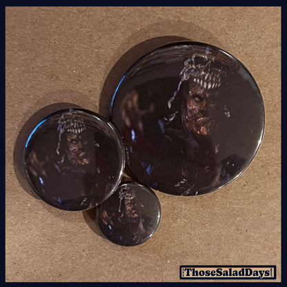 Three buttons of an Evil Dead type image. One size is 1", 1.5" and 2.25".