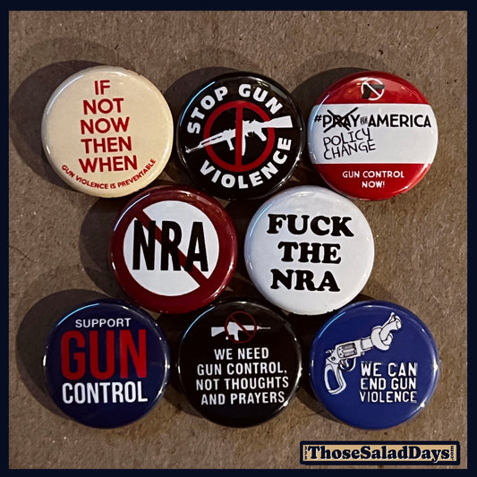 Collection of buttons with gun control and anti-gun violence messages on a brown background.