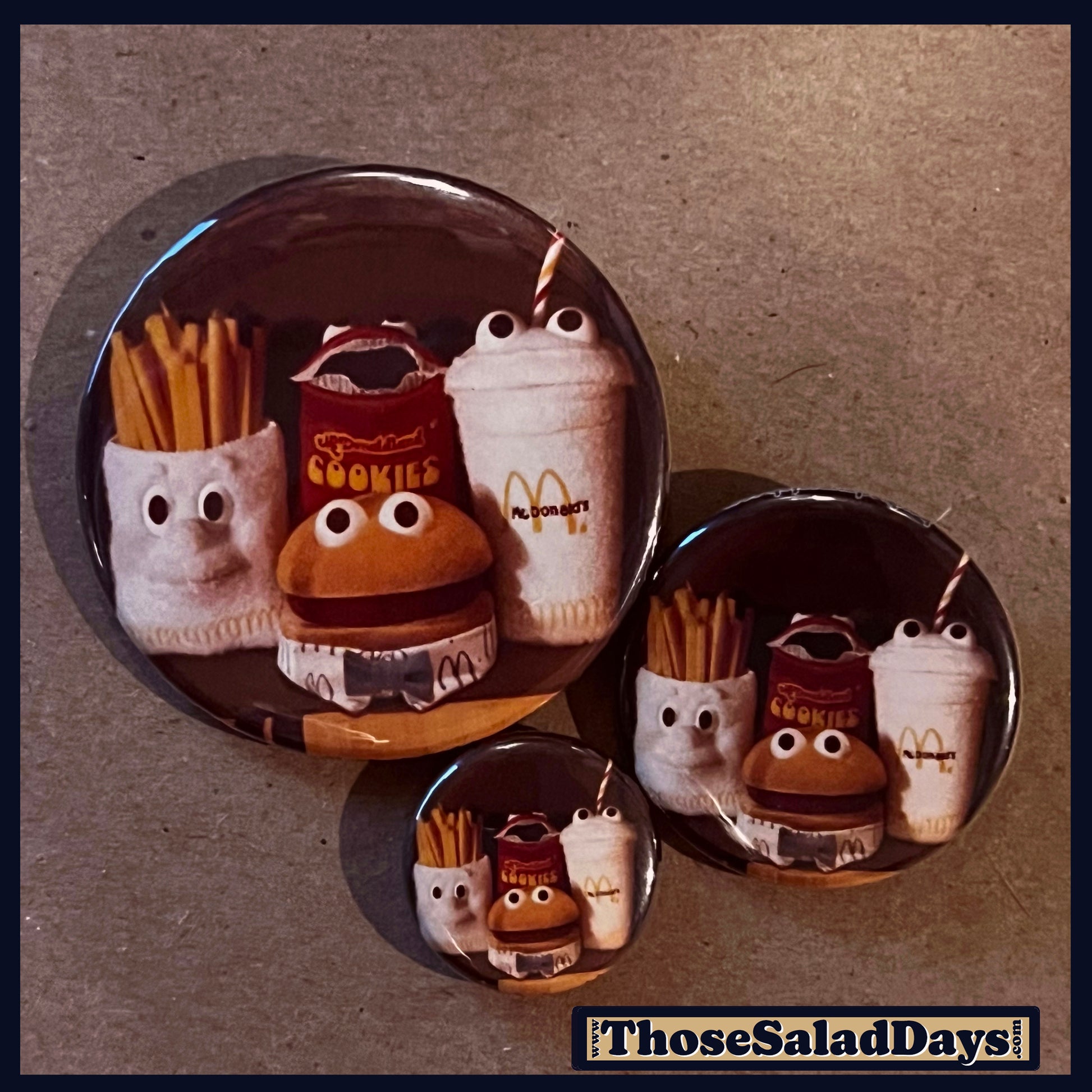 Set of three round pins with cartoonish food items from McDonalds