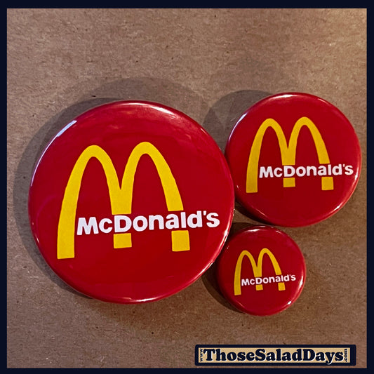 Three McDonald's logo buttons on a brown background