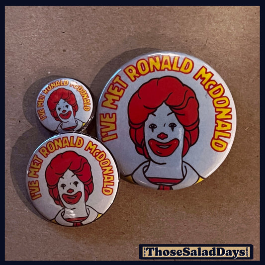 Three 'I've Met Ronald McDonald' buttons on a brown background.