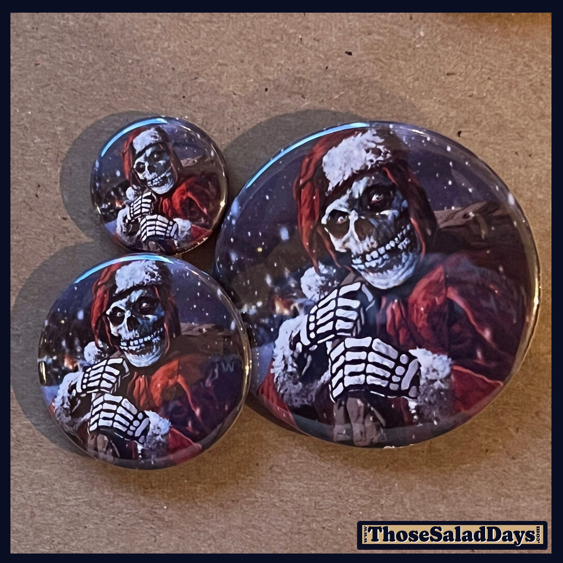 Three buttons with misfits fiend skeleton designs on a textured surface.