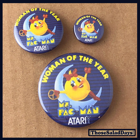 Three Atari buttons featuring 'Woman of the Year' Ms pac man