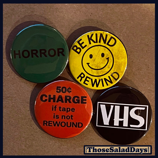 Four buttons with text and graphics from the rental days of the 80s and 90s