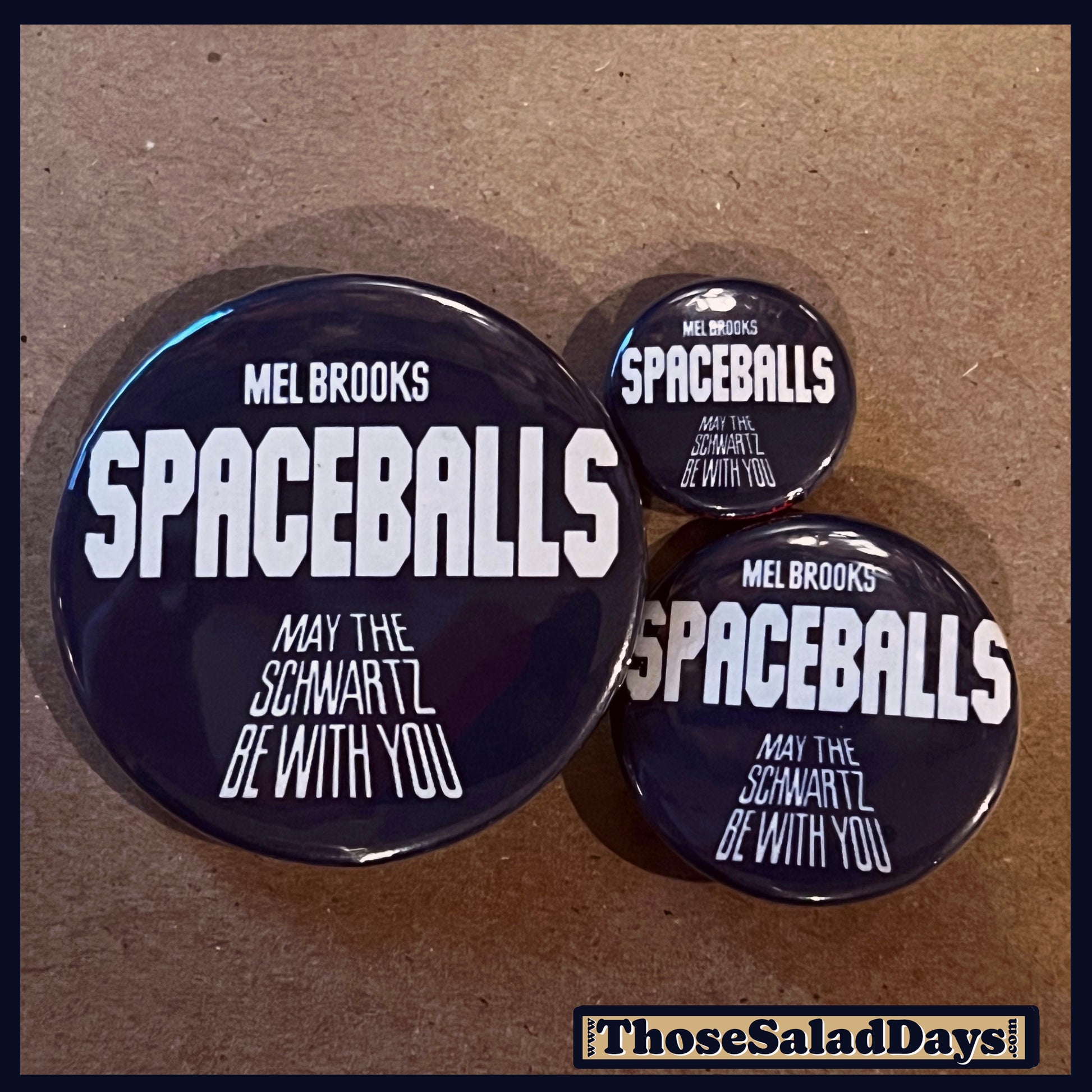 Three 'Spaceballs' themed buttons on a brown background