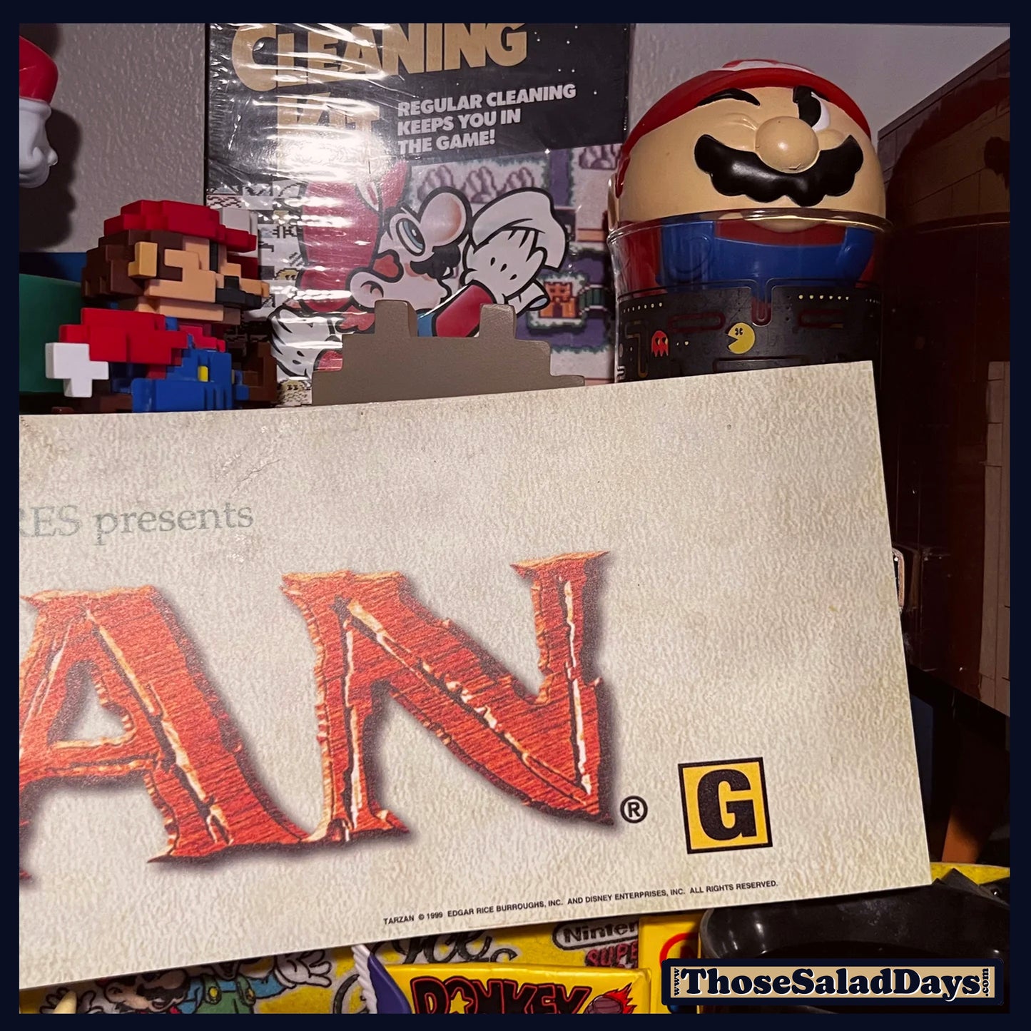 Product packaging with 'G' rating label and character figurines in the background