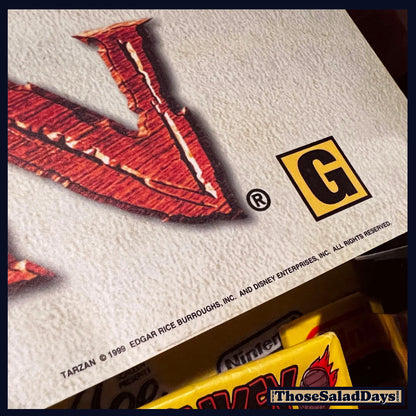 Close-up of a trading card with a red character and 'G' rating on a white background.