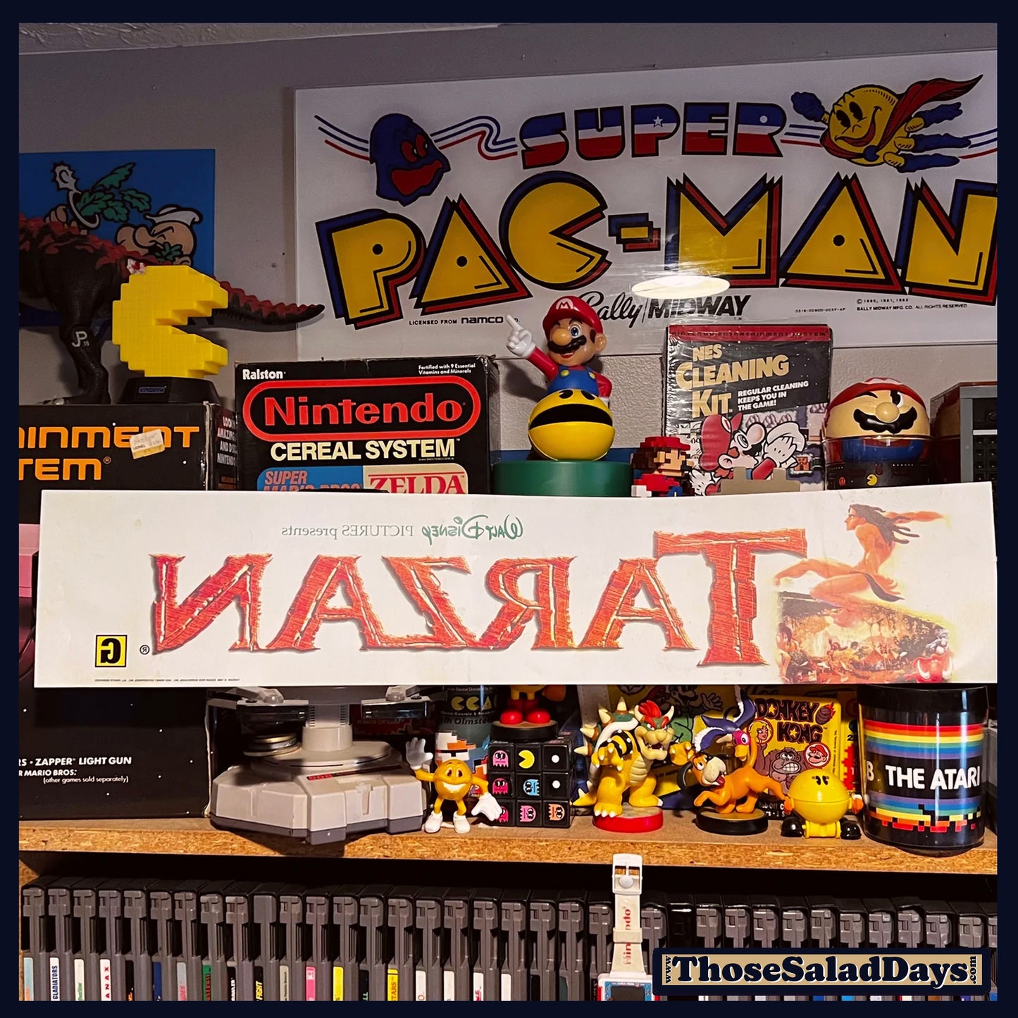 Collection of vintage gaming memorabilia including a Super Pac-Man sign and Atari products.