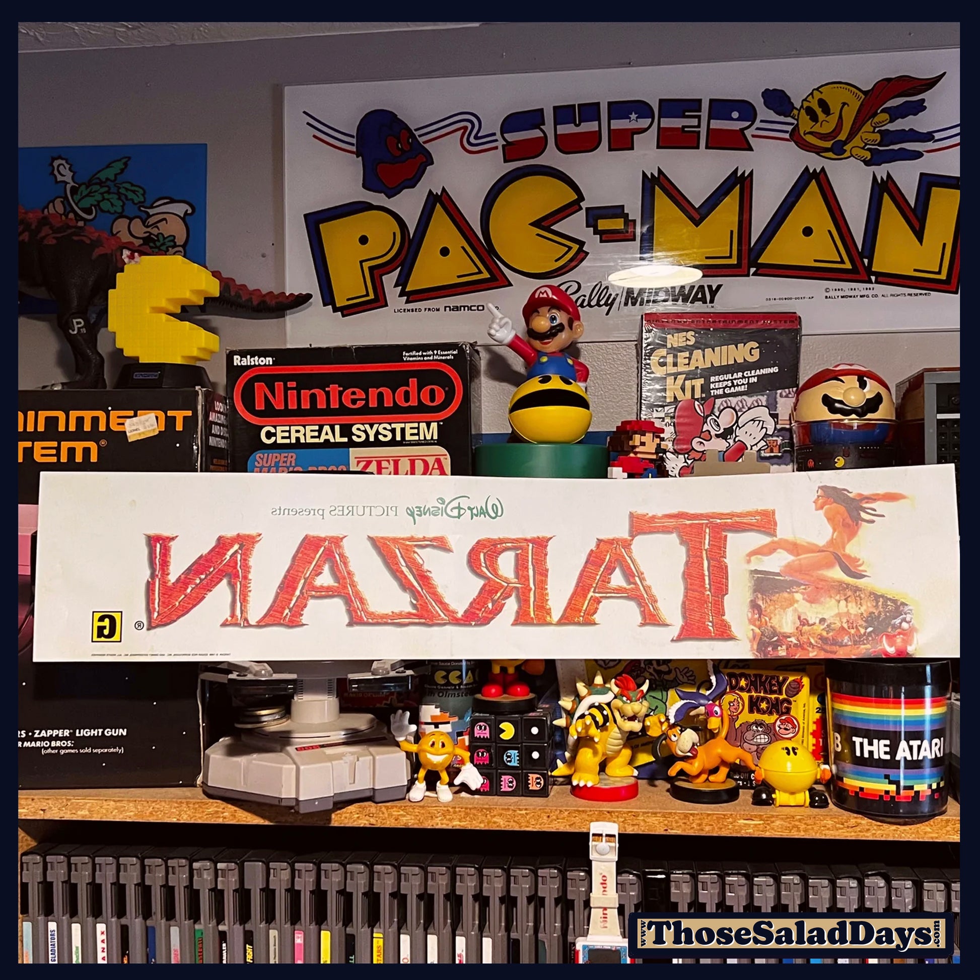 Collection of vintage gaming memorabilia including a Super Pac-Man sign and Atari products.